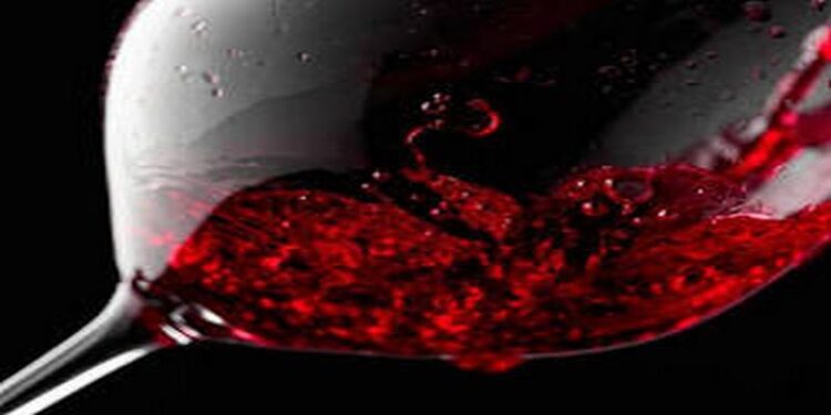 Ly rượu vang đỏ sóng sánh dưới ánh nắng tại vườn nho – biểu tượng của sự tinh tế và di sản văn hóa Ý